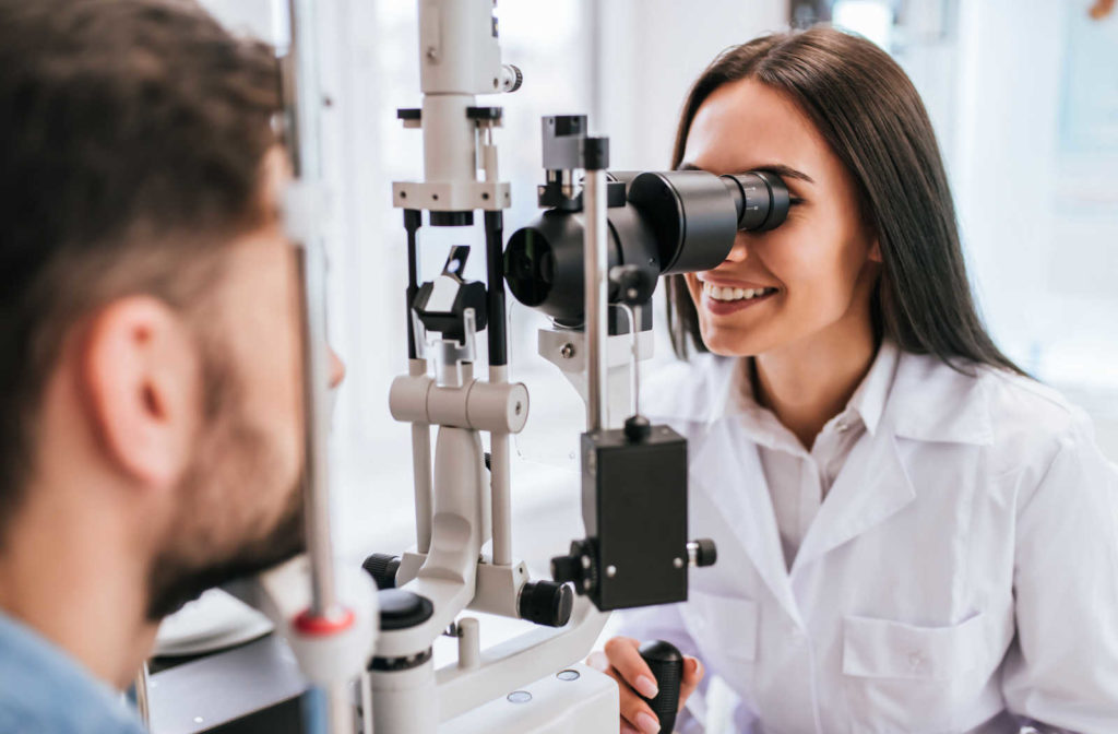 An optometrist performing an eye examination on a man using a specialized medical device to check for any eye problems.