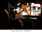 View from the backseat of a car looking out at the windshield, and a man in the drivers seat.