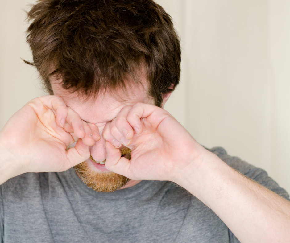 A man rubbing his eyes