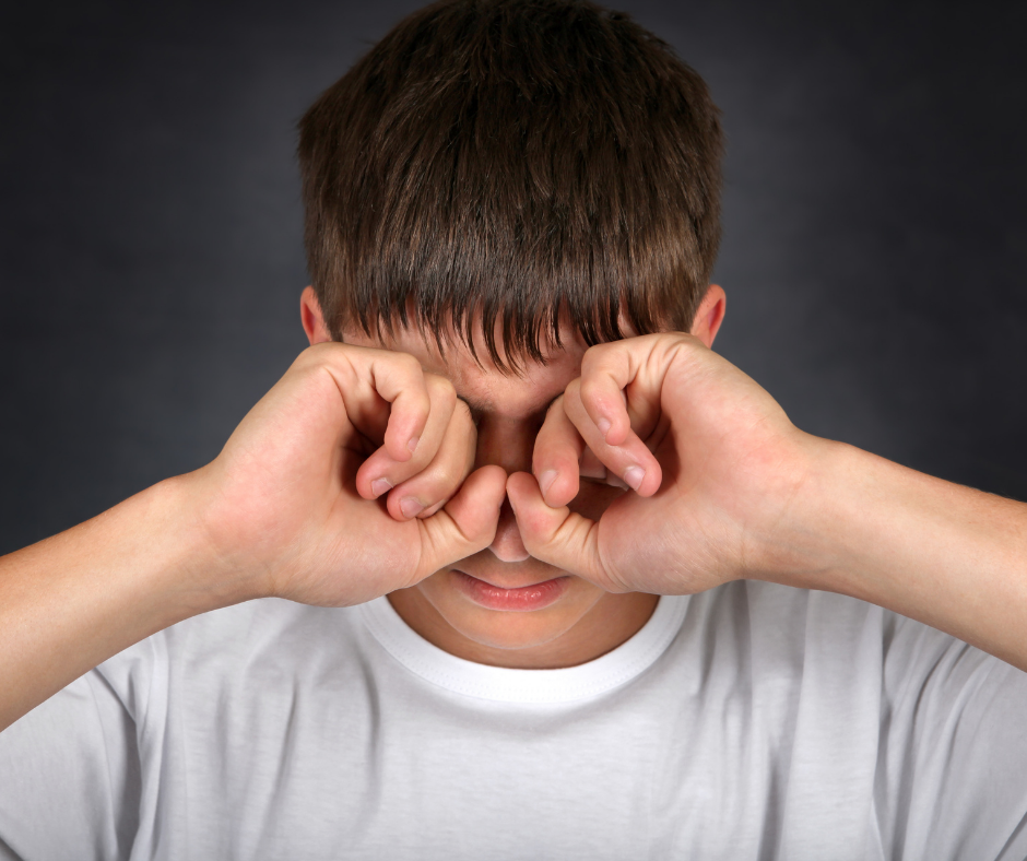 A boy rubbing his eyes